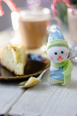 Christmas snowman holding spoon with christmas pie in hands.