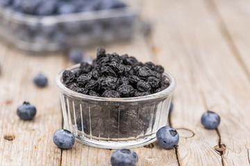 Dried Blueberries on wooden background; selective focus