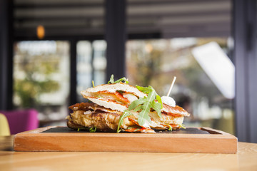 Sandwich with ham,tomato, cucumber and arugula on the wooden cutting board,background.