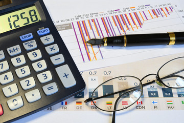 calculator, pen, glasses and paperwork. Office business concept image.