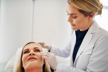 Doctor prepping the face of a woman for botox injections