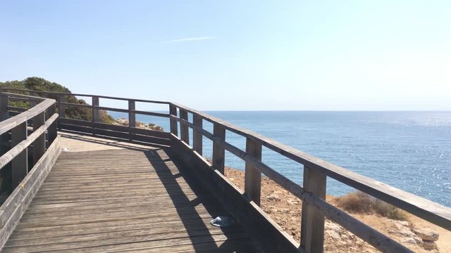 Wooden walkway to beautiful Carvoeiro beach with cliff and rock formation Algarve region Portugal.