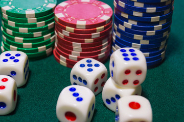 Dice and chips on green cloth closeup. A textured background.Copy paste place