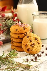Obraz na płótnie Canvas Chocolate chip cookies and glass of milk on festive Xmas background, selective focus