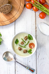 Top view of nice asparagus cream soup with toasted bread.