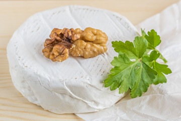 camembert and walnut on wooden background