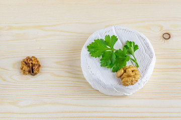 camembert and walnut on wooden background