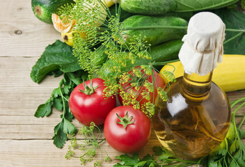 vegetables and  bottle of oil, still life on a wooden table
