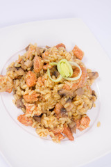 Risotto with mushrooms and chicken decorated with leek on a white background