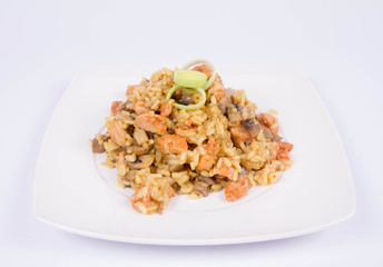 Risotto with mushrooms and chicken decorated with leek on a white background
