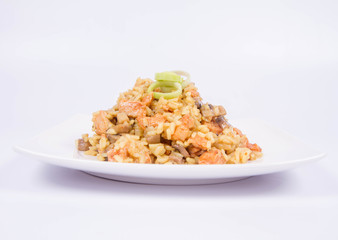 Risotto with mushrooms and chicken decorated with leek on a white background