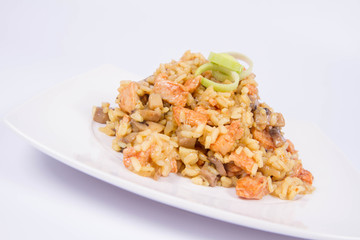 Risotto with mushrooms and chicken decorated with leek on a white background