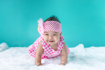 Portrait of cute asian baby in pink dress on carpet wool,happy baby concept,smile,thail little baby