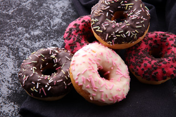 assorted donuts with chocolate frosted, pink glazed and sprinkles donuts.