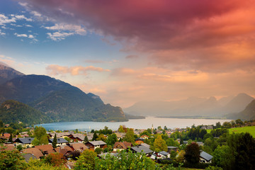 Picturesque sunset over small Austrian village of St. Gilgen, situated on Wolfgangsee lake, with spectacular mountains on the background.