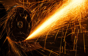 grinder cuts the metal with an abrasive sparks fly