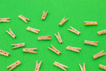 Set of wooden clothespins on bright green background