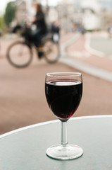 A glass of red wine on a table outside a bar in Amsterdam