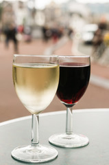 Glasses of white and red wine on a table outside a bar in Amsterdam
