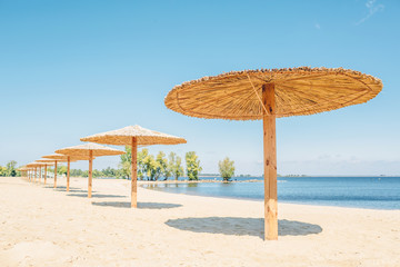 Sun shade bulrush umbrellas on the sand beach