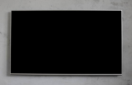 Empty black television screen on concrete wall