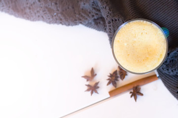 Turmeric latte and a warm blanket at sunset. the concept of comfort. read bestseller. warm home. Turmeric Latte with Nut Milk, cinnamon, honey, ginger