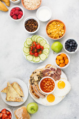 Full English breakfast, eggs, bacon, sausages, breads and fruits