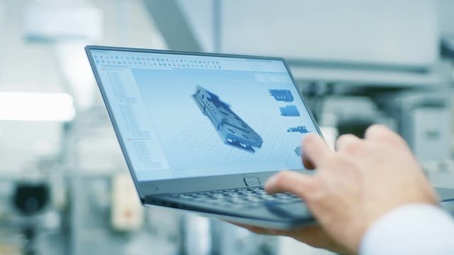 Close-up of the Engineer Holding Laptop with CAD Component Model on Screen. In the Background Modern Factory Equipment. Shot on RED EPIC-W 8K Helium Cinema Camera.