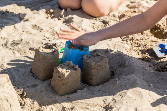 Barn bygger sandslott p&aring; sandstrand