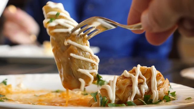 cabbage rolls on a platter, someone is eating cabbage rolls. 4k, slow motion