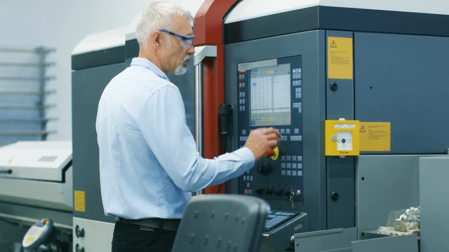 Chief Engineer/ Operator Programs/ Sets-up CNC Machine with Control Panel. He Works on the Modern Technologically Advanced Factory. Shot on RED EPIC-W 8K Helium Cinema Camera.