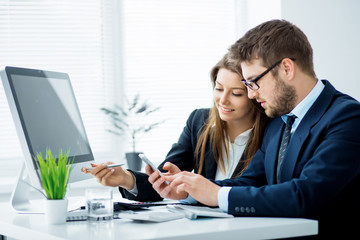 Fototapeta premium Young businessman discussing something with his colleague, and using a digital tablet together