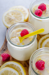 Lemon or vanilla curd in glass jars with raspberry and lemon sli