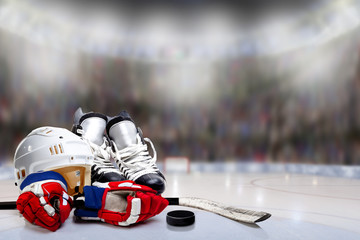 Obraz premium Ice Hockey Helmet, Skates, Gloves, Stick and Puck in Hockey Rink