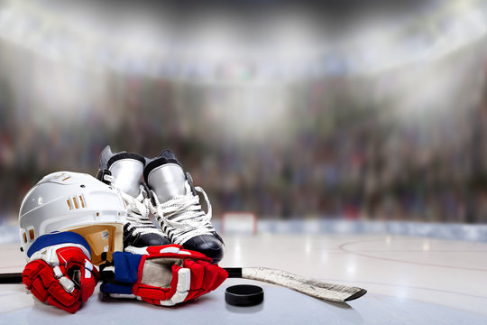 Ice Hockey Helmet, Skates, Gloves, Stick and Puck in Hockey Rink