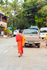 Fototapeta na wymiar Monks on a city street in Louangphabang, Laos. Copy space for text. Vertical.