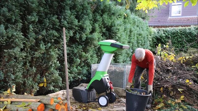 Herbst-Arbeitsplatz im Garten mit H&auml;cksler und Komposthaufen