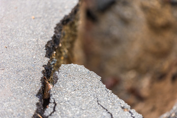 Asphalt road cracked and broken from earthquake, Louangphabang, Laos. Close-up..