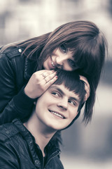 Happy young couple in love hugging in city street