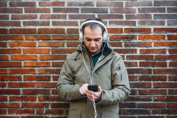Man listens to music with headphones and smart phone.