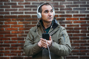 Man listens to music with headphones and smart phone.