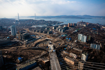 Fototapeta na wymiar Amazing zooming out aerial view of the Zolotoy Bridge (the Golden Bridge) that is cable-stayed bridge across the Zolotoy Rog built in 2012 in Vladivostok, Russia, and cars driving on it.