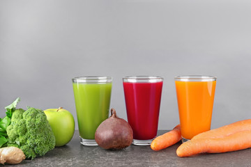 Glasses with various fresh juices and ingredients on table