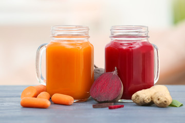 Mason jars with various fresh vegetable juices and ingredients on table