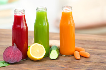 Fototapeta na wymiar Bottles with various fresh vegetable juices and ingredients on table