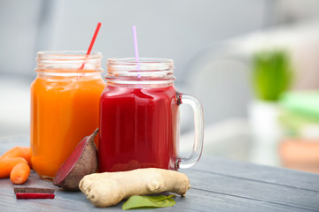 Mason jars with various fresh vegetable juices and ingredients on table