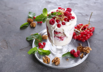 Oatmeal dessert with yogurt and viburnum in glass on table