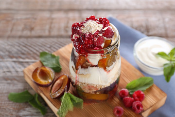 Oatmeal dessert with yogurt and raspberries in jar on table