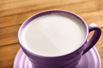Cup with yummy cocoa on wooden table, closeup