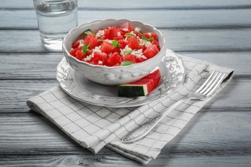 Bowl with delicious watermelon salad on wooden table